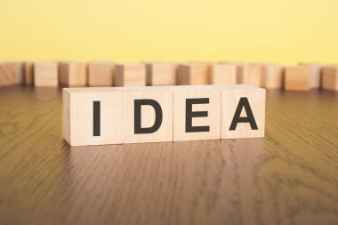 Kısa kelime İngilizce harfleri, küçük tahta bloklar üzerinde IDEA yazılı. kahverengi arka plan. seçim odağı.