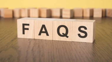 Kısa kelime İngilizce harfleri ve küçük tahta bloklar üzerinde FAQS yazıyor. kahverengi arka plan. seçim odağı.
