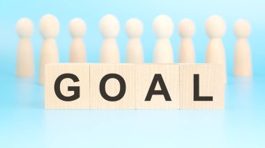 İş ve finans kavramı. Mavi yüzeyde ahşap figürler ve yazılı bloklar var.