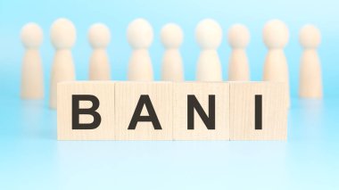 İş ve finans kavramı. Mavi yüzeyde tahta figürler ve yazılı bloklar var - BANI