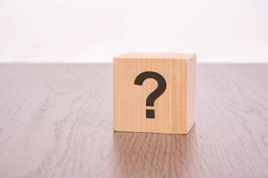 Gri arkaplan üzerinde soru işaretleri olan üç tahta blok.
