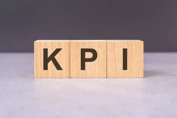 KPI - acronym from wooden blocks with letters, top view on black background
