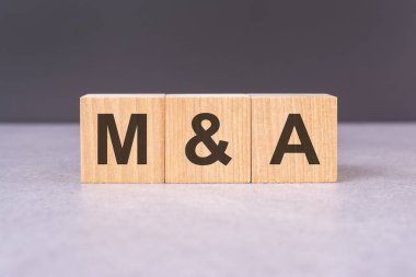 M and A - acronym from wooden blocks with letters, top view on black background clipart