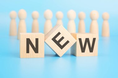 Ön planda 'Yeni' kelimesini oluşturan blokların düzenlenmesi yenilik, tazelik ve ileri görüşlü bir yaklaşımı vurguluyor, yenilik ve orijinallik duygusunu teşvik ediyor..