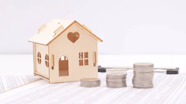 real estate and buy house concept, stacked of lots coins on wood table with model house, saving money to pay for investment property and residential