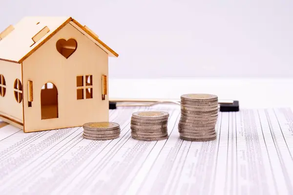 real estate and buy house concept, stacked of lots coins on wood table with model house, saving money to pay for investment property and residential