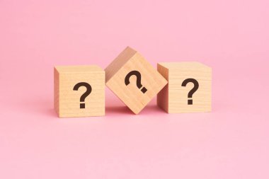 Ahşap küplere karşı pembe arkaplan sorusu soruşturma, merak, problem çözme ve cevap arama kavramını ortaya koyar.