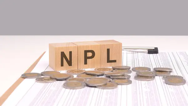 Npl 与硬币一起拼法的木制块形象所强调的概念表明 重点是评估和管理不良资产 以减少金融风险并优化资产质量 图库照片