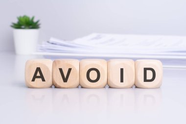 Üzerinde 'Uzak durun' yazan tahta bloklar, iş dünyasındaki hatalardan kaçınma üzerine odaklanmış motivasyon mesajları sergiliyor.