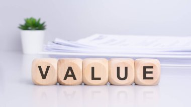 'VALUE' diye hecelenen ahşap bloklar tarafından aktarılan konsept, iş ve karar verme bağlamlarında değer, önem ve öneme odaklanmayı öneriyor..