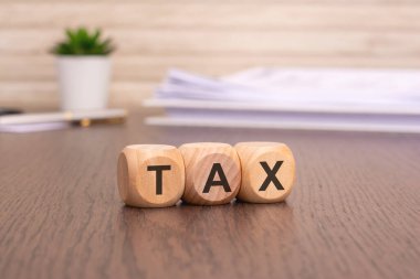 Fotokopi alanı, finansal konsept arka planı ve bulanık arkaplan üzerindeki ahşap küplere TAX