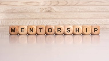 Ahşap küpler MENTORSHIH 'i simgeler, profesyonel gelişimi, rehberliği ve desteği sembolize eder, başkalarının amaçlarına ulaşmalarına ve yeteneklerini geliştirmelerine yardımcı olmak için deneyimli bireyler tarafından sağlanır.