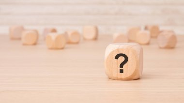 Bir tarafında soru işareti sembolü olan tahta bir küp.