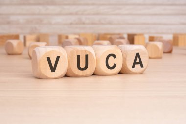 Ahşap arka planı olan tahta küplerde kısaltma VUCA. kopyalama alanı konsepti. seçim odağı