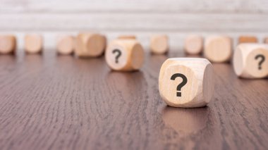 Tahta bir arka planda duran soru işareti bloklu konsept