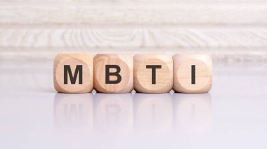 MBTI kelimesi tahta küp yapısına yazılmıştır. Parlak gri arkaplandaki küplerin yansıması. seçici odak.