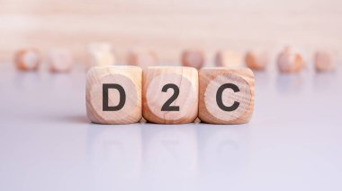 D2C metni - Doğrudan Tüketiciye (Direct to Exsumer) nin kısaltması her biri farklı yazı tipine sahip ahşap küplere güzelce işlenmiş.