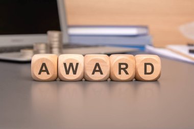 'AWARD' konsepti, kalemler, defterler ve kitaplar içeren ahşap bloklar.