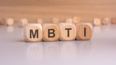 Bu fotoğraf, kişilik değerlendirmelerini, psikolojik testleri veya kişisel gelişim kavramlarını resmetmek için mükemmel olan ahşap zar heceleme MBTI 'sini içerir.