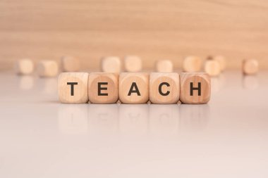 Bu fotoğraf 'TEACH' hecelenen ahşap zar içeriyor, eğitim, eğitim ve öğrenmeyle ilgili kavramları göstermek için mükemmel.