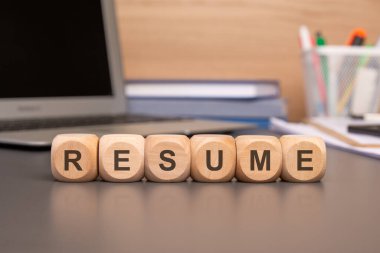 Özgeçmiş kelimesi arka plandaki tahta küplere yazılır. Finansal tablolarda yer alan bir hesap makinesi. yüksek kaliteli fotoğraf