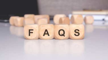 Tahta bloklar FAQS olarak hecelenir, yaygın sorulan sorular ve cevaplar için bir kaynağı sembolize eder, çeşitli konularda netlik ve yardım sağlar