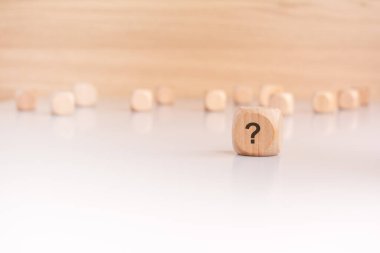 Üzerinde soru işareti olan tahta bir küp, ön plana belirgin bir şekilde yerleştirilmiş. Arka planda odağını kaybetmiş sayısız tahta küp derinlik ve merak duygusu yaratıyor..