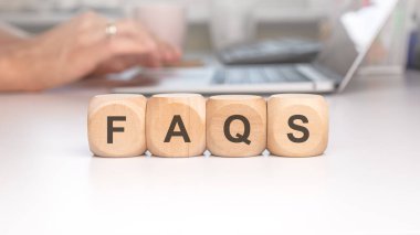 FAQS ahşap bloklar yaygın olarak sorulan sorular ve cevaplar için kaynak sembolize bir dizüstü bilgisayarla bir masada