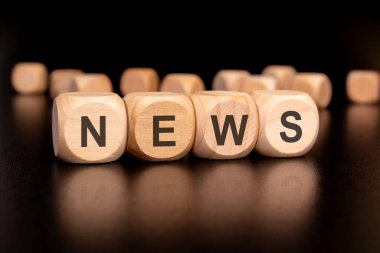 Medya ve içerik oluşturma için ideal kelime olan NEWS 'i heceleyen çeşitli renkli tahta blokların yakın plan resmi