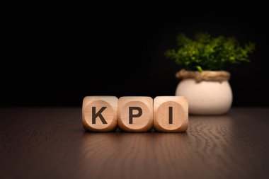 Tahta bloklar zarif bir şekilde KPI 'yi hecelemek için düzenlenmiş, anahtar performans göstergelerini şık bir ayarda temsil ediyor