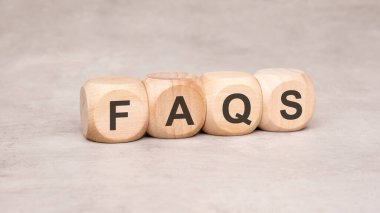 Bir resim, bilgilendirici ve eğitici içerik için ideal olan FAQ kelimesinin gösterildiği tahta blokları gösterir