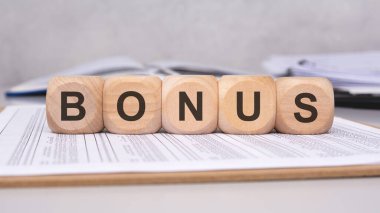 Tahta bloklar çeşitli finansal belgelerde BONUS sözcüğünün belirgin bir şekilde sergilenmesi, ek gelirleri simgeliyor