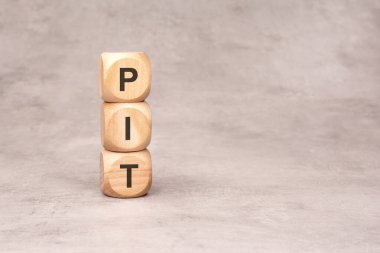 PIT sözcüğünü oluşturmak için üç tahta blok bir araya getirildi.