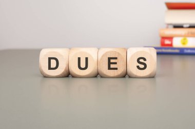 Modern bir masa seti, üzerinde DUES sözcüğünün belirgin bir şekilde sergilendiği tahta bloklarla süslenir.