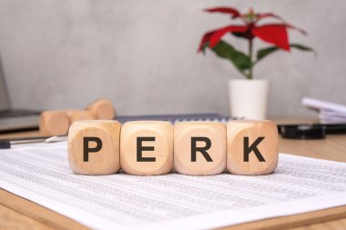 Canlı bir bitkiye sahip bir masa, büyümeye bağlı faydaları sembolize eden PERK hecelenen ahşap bloklar içerir.