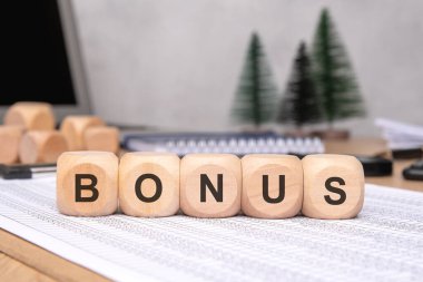 BONUS 'un hecelenen tahta bloklar ofis aksesuarları ve yeşilliklerle dolu bir masada davetkâr bir çalışma alanı yaratıyorlar.