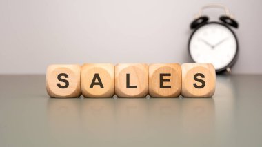 Çalar saatin yanında ahşap bloklar var. Günümüz satış stratejilerinde aciliyeti simgeliyor.