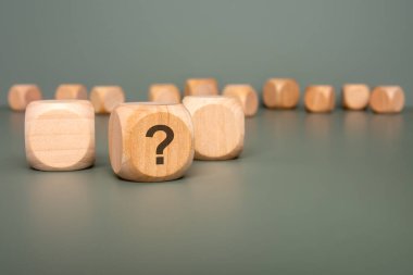 Tahta küplerin detaylı yakın plan görüntüsü soruşturma ve merakın özünü temsil eden soru işaretleri sergiliyor.