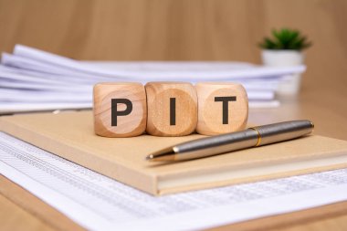 Şık bir çalışma alanı, ahşap harflerle PIT 'yi parlak bir kalemin yanındaki deftere yazıp ilham veriyor.