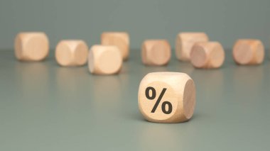 Önemli finansal kavramları ve istatistikleri vurgulayan, yüzde bir sembol gösteren ahşap bir blok