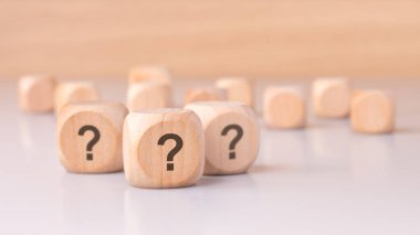 Tahta küpler soru işaretleriyle süslenmiş basit ama merak uyandıran bir ortamda merak ve gizemi temsil ediyor.