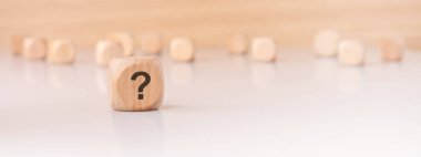 Belirgin bir soru işareti gösteren tahta blok, genel olarak hem soruşturma hem de merakı sembolize eder.