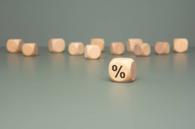 Önemli finansal kavramları ve istatistikleri vurgulayan, yüzde bir sembol gösteren ahşap bir blok