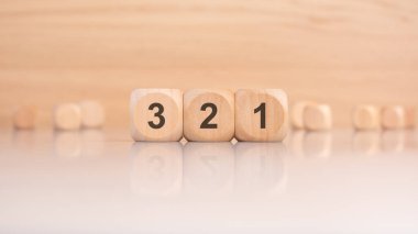 3 'ten 1' e kadar bir geri sayım sergileyen minimalist bir sanat eseri numaralar için güzelce işlenmiş ahşap bloklar kullanıyor.