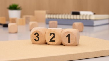 3 'ten 1' e kadar bir geri sayımı yaratıcı bir şekilde temsil etmek için sanatsal olarak düzenlenmiş bir ahşap blok seti.