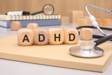 Adhd kelimesi, steteskoplu gri arkaplandaki tahta küplerden yapılmıştır.
