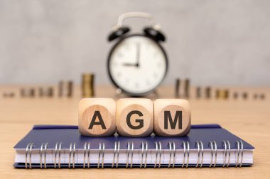 Yıllık Genel Kurul 'u sembolize eden' AGM 'harfli tahta bloklar. asgari iş konsepti görüntüsü.