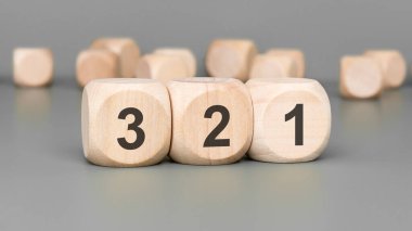 Gri arka planda 3, 2, 1 numaralı tahta küpler. sıralama kavramı.