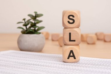 SLA kısaltmalı küpler - servis seviyesi anlaşması - bir kağıt belge üzerinde