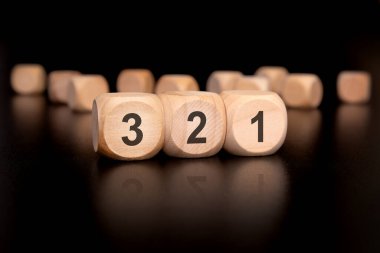 3 'ten 1' e kadar geri sayım gösteren minimalist bir sanat eseri. Siyah arkaplandaki rakamlar için güzelce işlenmiş ahşap bloklar kullanılıyor.